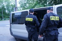 Policjanci otwierają drzwi radiowozu