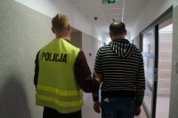 Policjant prowadzi zatrzymanego