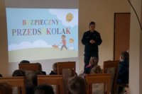 Dzieci z przedszkola nr 4 w trakcie zajęć prowadzonych przez umundurowana policjantkę w sali edukacyjnej mieszczącej się na terenie siedziby Zespołu Policji Konnej w Chorzowie