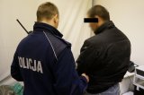 policjant z zatrzymanym mężczyzną