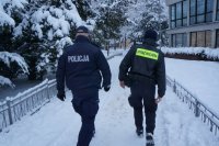 policjant, strażnik miejski i załoga pogotowia ratunkowego w trakcie udzielania pomocy mężczyźnie