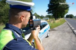 policjant w trakcie pomiaru prędkości