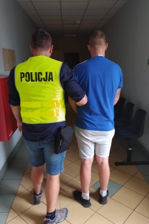 policjant operacyjny trzymający zatrzymanego