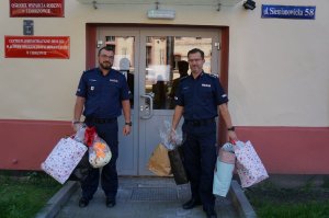 umundurowani policjanci w trakcie przekazywania maskotek