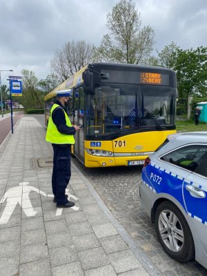 policjant kontrolujący autobus