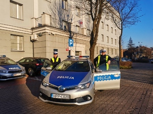 Zdjęcie przedstawia policjantów, których dotyczą podziękowania stojących obok radiowozu.