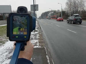 Zdjęcie przedstawia urządzenie do pomiaru prędkości trzymane przez policjanta