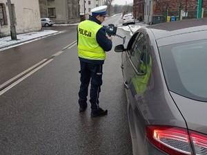 Zdjęcie przedstawia policjanta podczas kontroli drogowej