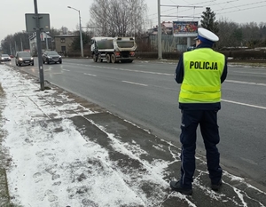 Zdjęcie przedstawia policjanta podczas pomiaru prędkości