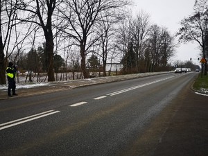 Zdjęcie przedstawia policjanta podczas pomiaru prędkości