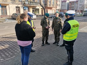 Zdjęcie przedstawia policjantów oraz uczniów podczas wręczania mandatów zaufania