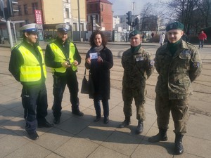 Zdjęcie przedstawia policjantów oraz uczniów podczas wręczania mandatów zaufania