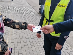 Zdjęcie przedstawia policjantów oraz uczniów podczas wręczania mandatów zaufania