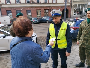 Zdjęcie przedstawia policjantów oraz uczniów podczas wręczania mandatów zaufania