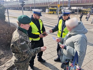 Zdjęcie przedstawia policjantów oraz uczniów podczas wręczania mandatów zaufania