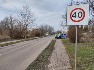 Zdjęcie przedstawia znak ograniczający prędkość do 40 km\h w tle policjanci