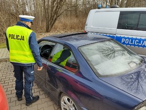 Zdjęcie przedstawia policjanta podczas kontroli drogowej