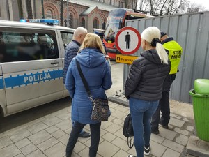 Zdjęcie przedstawia policjanta oraz strażnika miejskiego podczas legitymowania