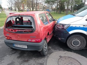 Zdjęcie przedstawia pojazd uciekinierów oraz policyjny radiowóz.