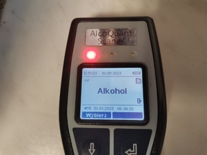 Zdjęcie przedstawia urządzenie do pomiaru alkoholu w wydychanym powietrzu wskazujące jego obecność.