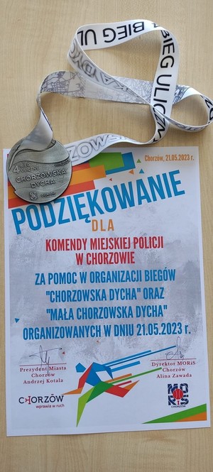 Zdjęcie przedstawia podziękowanie oraz pamiątkowy medal