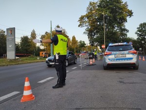 Zdjęcie przedstawia policjanta kierującego ruchem