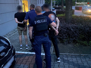 Zdjęcie przedstawia sprawców rozboju wraz z policjantami wchodzących do komendy