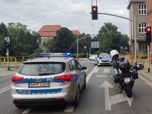 Zdjęcie przedstawia pojazdy policyjne oraz motocykl uciekiniera