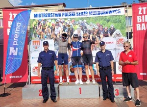 Zdjęcie przedstawia zawodniczki na podium, obok stoją umundurowani policjanci