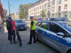 Zdjęcie przedstawia dwóch policjantów podczas rowerzysty