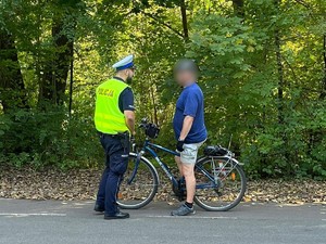 Zdjęcie przedstawia policjanta podczas kontroli rowerzysty