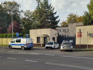 Zdjęcie przedstawia radiowozy przed budynkiem WCR