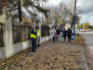 Zdjęcie przedstawia policjanta w rejonie cmentarza
