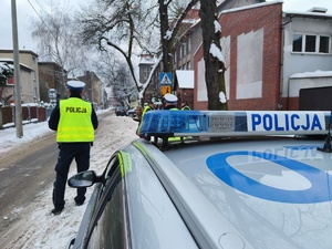 Zdjęcie przedstawia policjanta oraz radiowóz