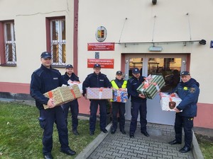 Zdjęcie przedstawia policjantów i strażników przed budynkiem OWR