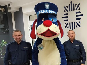 Zdjęcie przedstawia policjanta prewencji i nową maskotkę