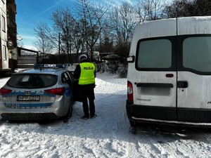 Zdjęcie przedstawia policjanta drogówki podczas kontroli