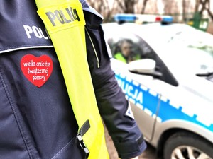 Zdjęcie przedstawia policjanta drogówki z sercem WOŚP