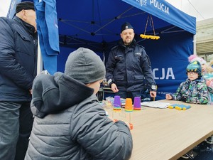 Zdjęcie przedstawia policjanta oraz dziecko biorące udział w konkursie