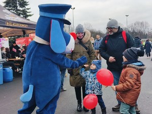 Zdjęcie przedstawia Sznupka przybijającego piątkę z dzieckiem