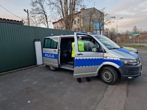 Zdjęcie przedstawia policjanta oraz radiowóz