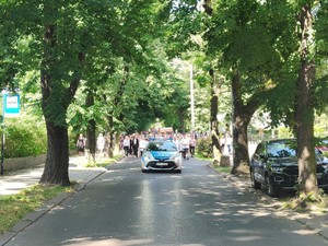 Zdjęcie przedstawia policyjny radiowóz na czele procesji