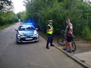 Zdjęcie przedstawia kontrolę rowerzysty przez policjanta drogówki