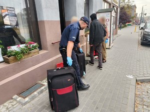 Zdjęcie przedstawia policjanta pracowniczkę oraz osobę w kryzysie bezdomności przed wejściem do fundacji