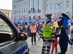 Zdjęcie przedstawia Sznupka oraz maskotkę Straży Miejskiej wraz z dziećmi