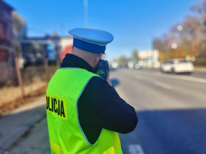 Na zdjęciu policjant drogówki wykonujący pomiar prędkości.