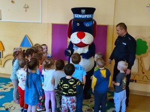 Na zdjęciu policjant, Sznupek oraz grupa przedszklaków.