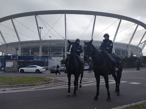 Na zdjęciu patrol policji konnej na tle stadionu.