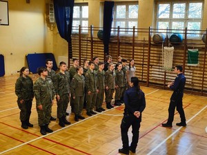 Na zdjęciu klasa mundurowa i dwójka policjantów.