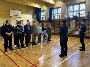 Na zdjęciu uczniowie szkoły i dwójka policjantów ze sztandarem.